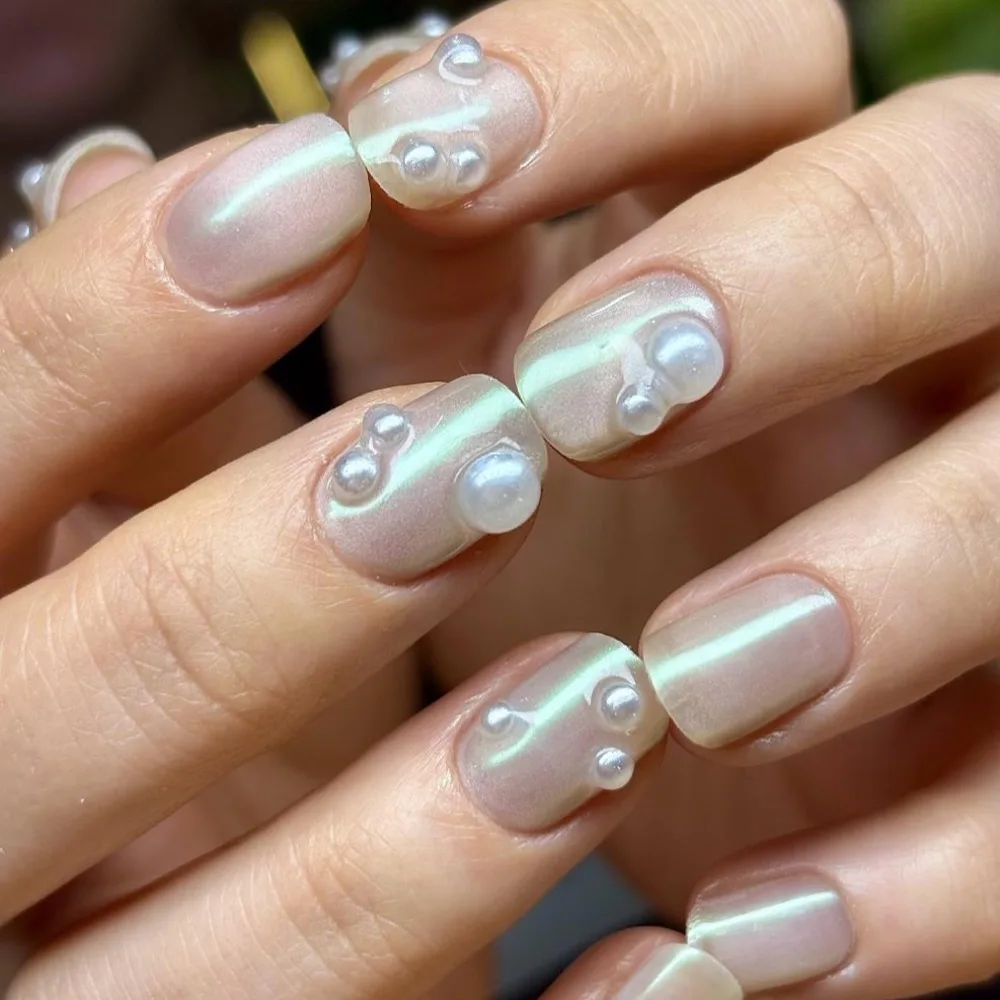 Nude gel manicure with 3D pearl accents, done at Norm