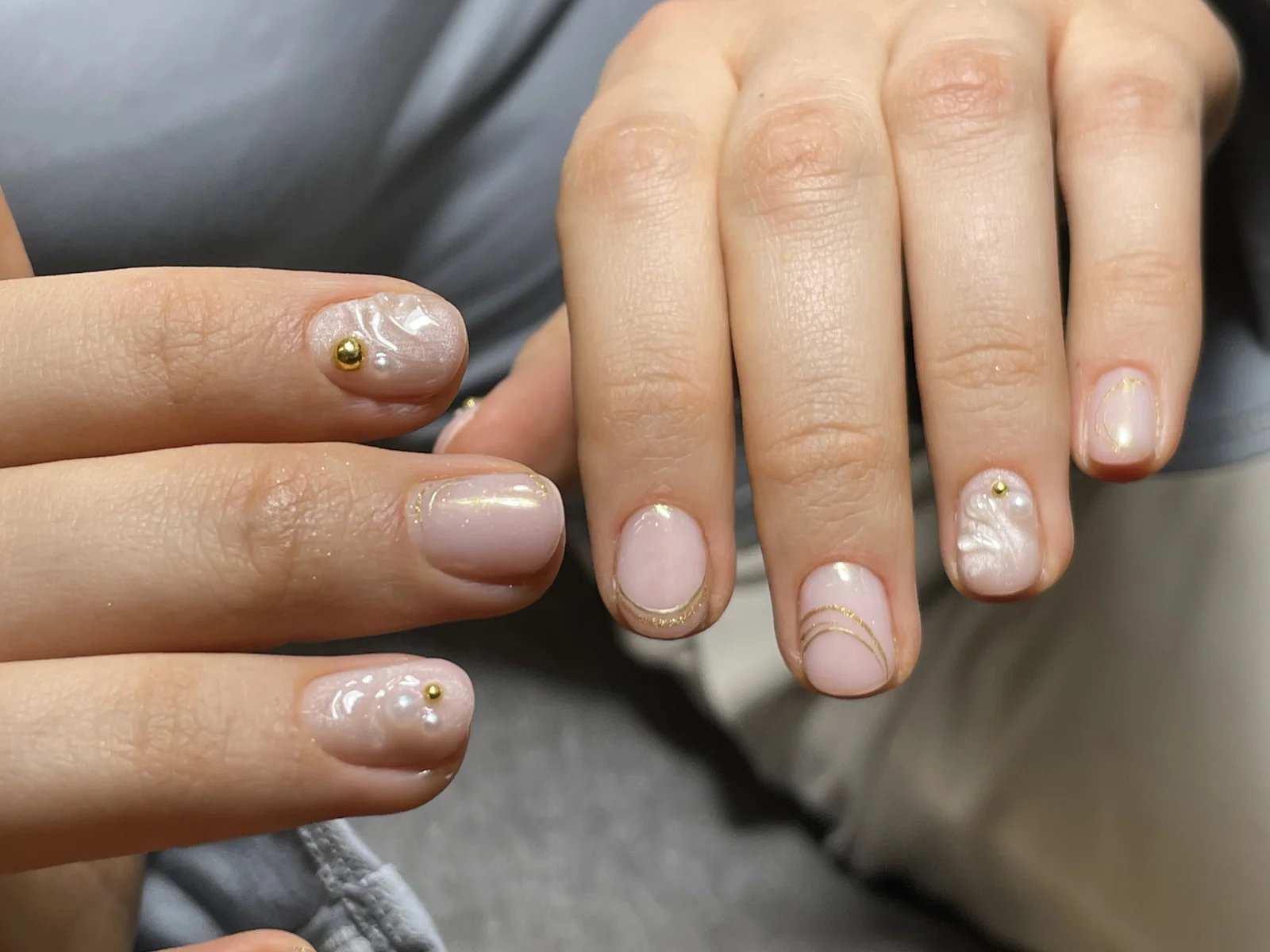 Nude gel manicure with gold linework and pearl accents, done at Norm